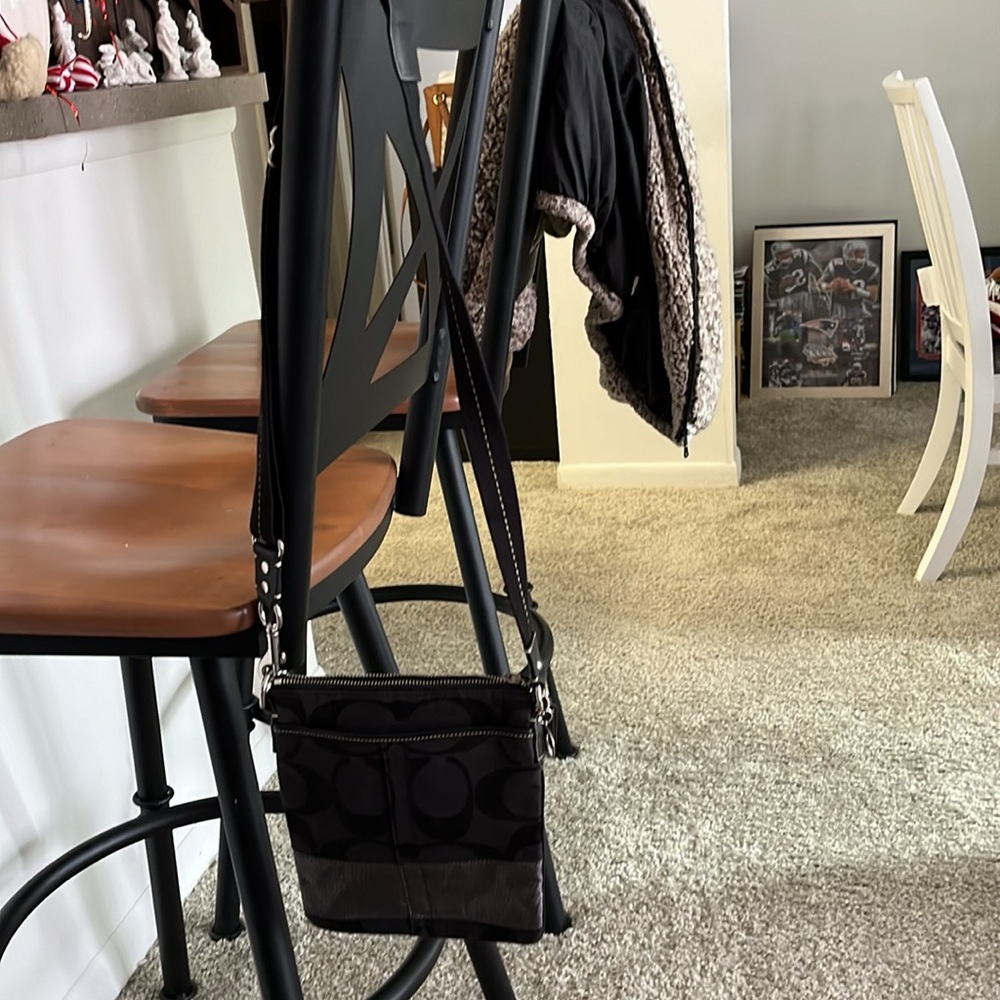 This is an authentic small crossover Coach bag that is black and silver